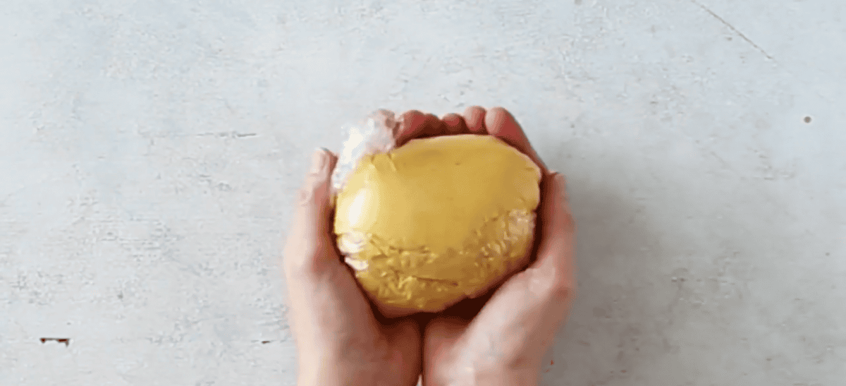 Cheese ball wrapped in plastic wrap.