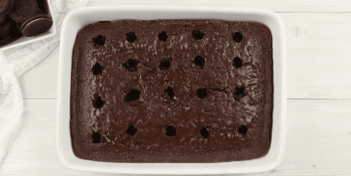 Chocolate cake with holes in it for a poke cake.