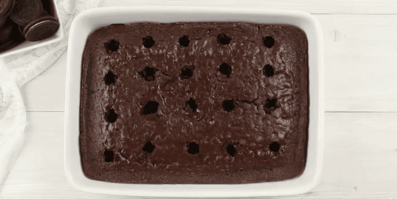 Chocolate cake with holes in it for a poke cake.