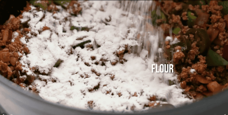 Flour being added to turkey chili