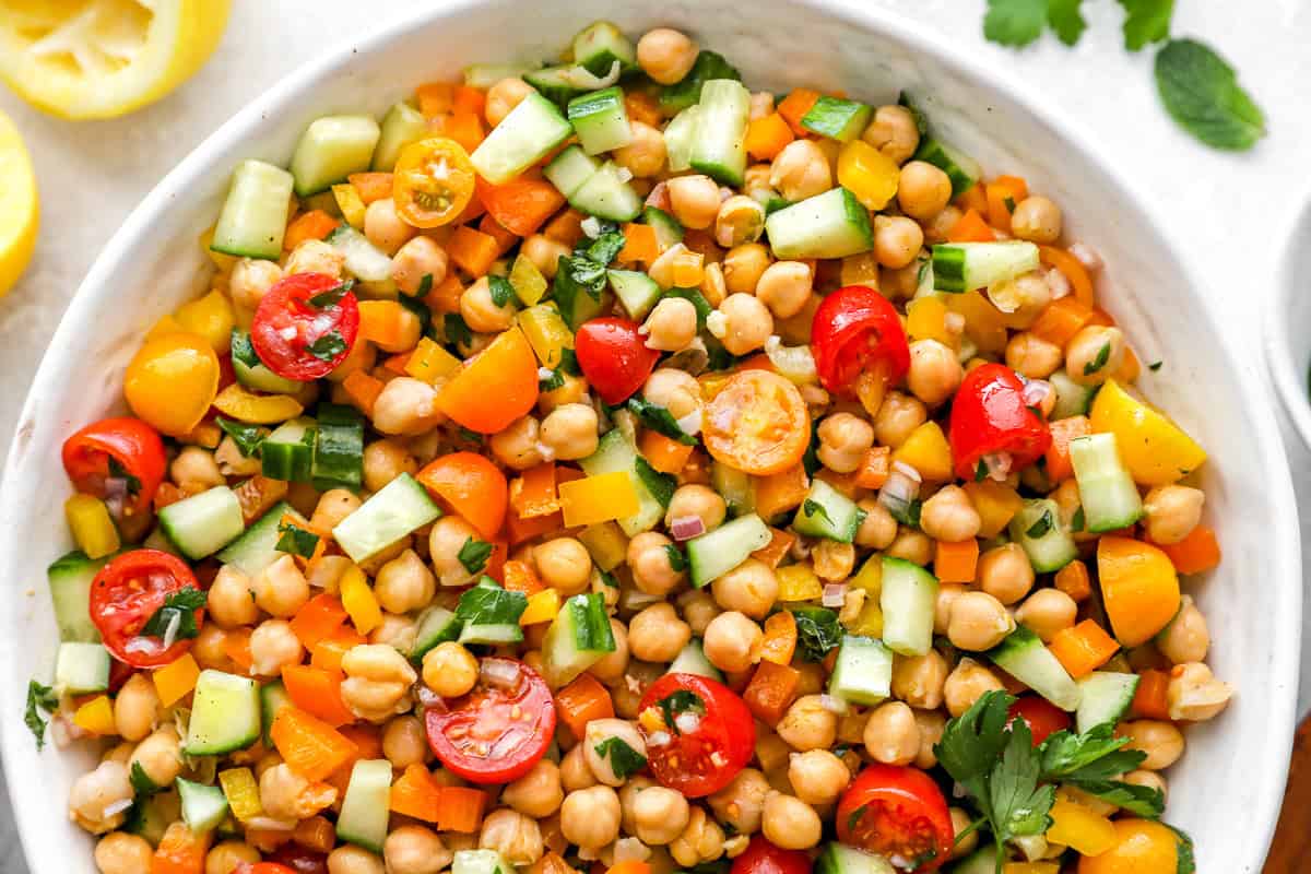 Close-up of the chickpea salad showcasing vibrant textures and colors—crisp cucumber, juicy tomatoes, sweet bell peppers, and fresh herbs mixed with chickpeas.