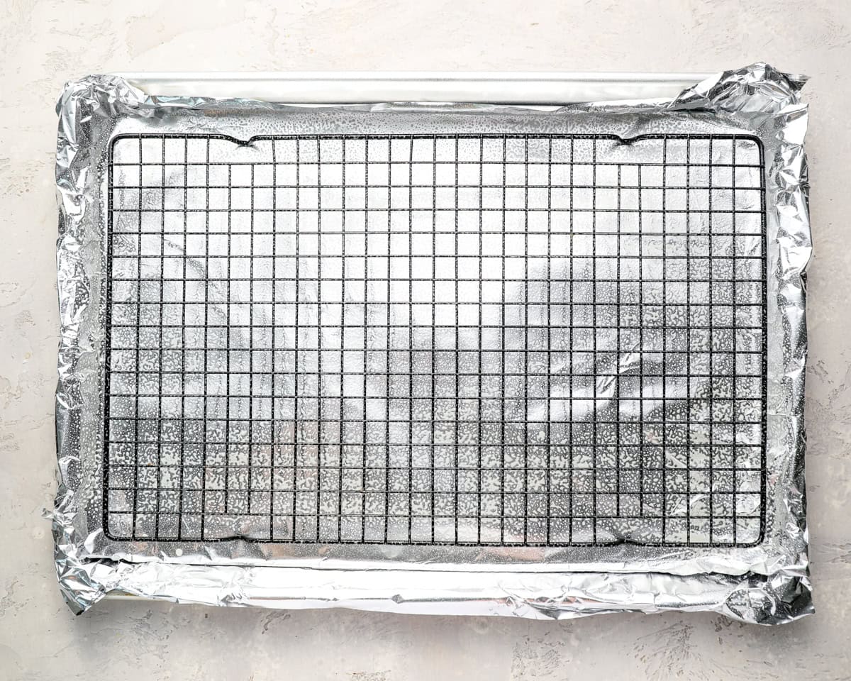Sheet pan lined with foil and topped with a wire cooling rack, sprayed and ready for baking.