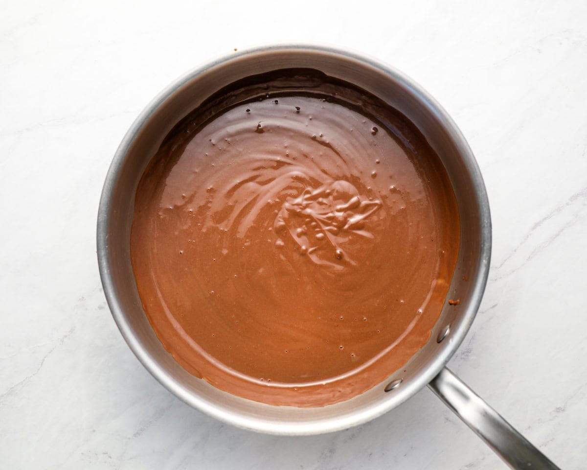 Chocolate pudding after adding butter and vanilla, now extra smooth and shiny in the saucepan.