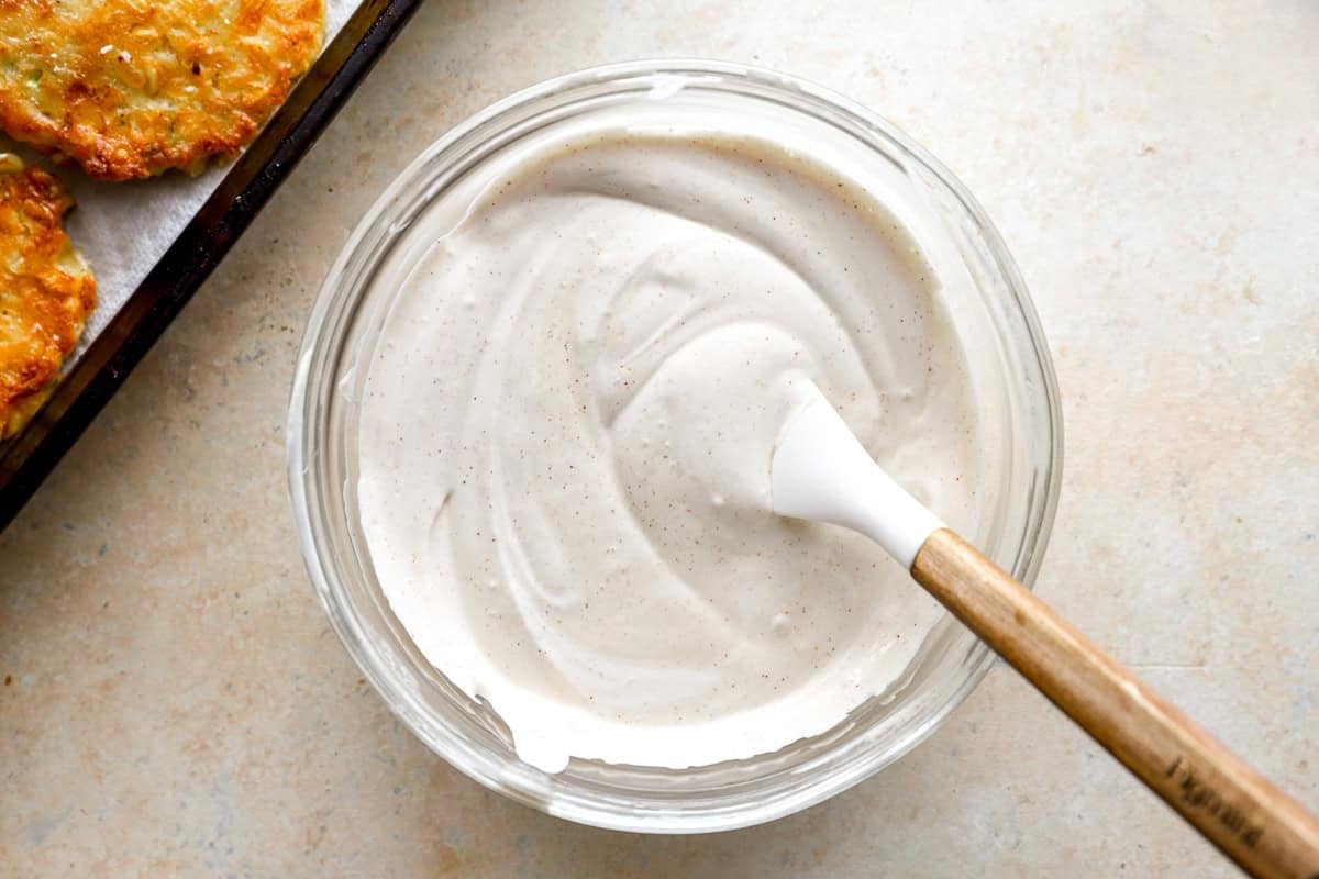 Creamy sour cream dip in a glass bowl with a spatula, ready to serve.