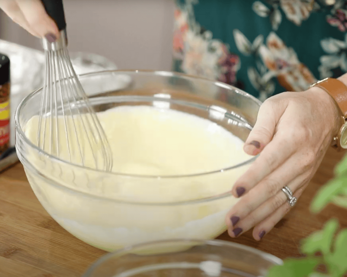 Mixing wet ingredients until smooth in a clear glass bowl