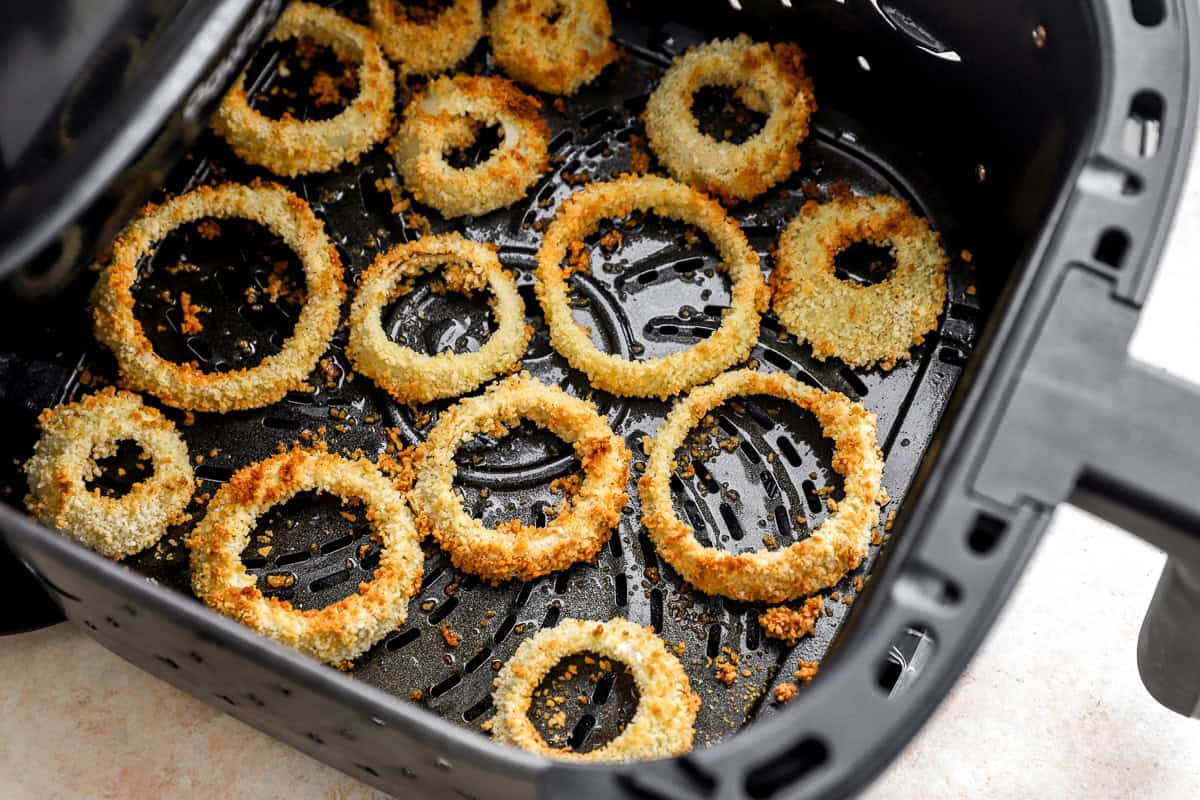 Crispy, golden air fryer onion rings in the basket after cooking, ready to serve.