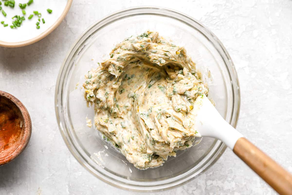 Cowboy butter mixture fully combined in a glass bowl with a spatula.