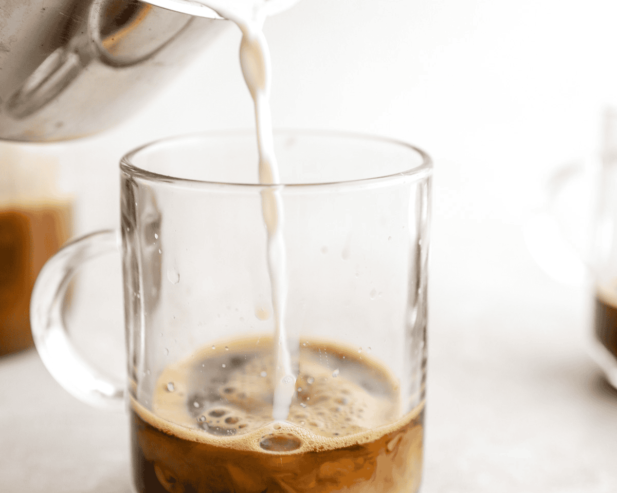 Milk being poured into espresso to make a banana bread latte