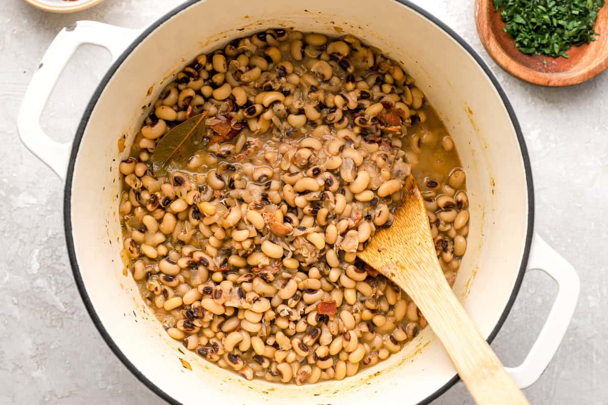 wooden spoon stirring a pot of black eyed peas