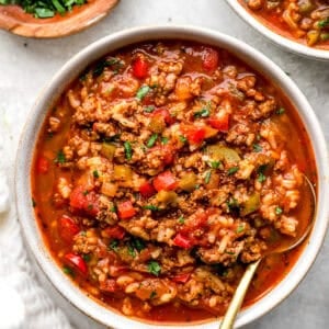 Bowl of crockpot stuffed pepper soup with ground beef, rice, bell peppers, and fresh parsley