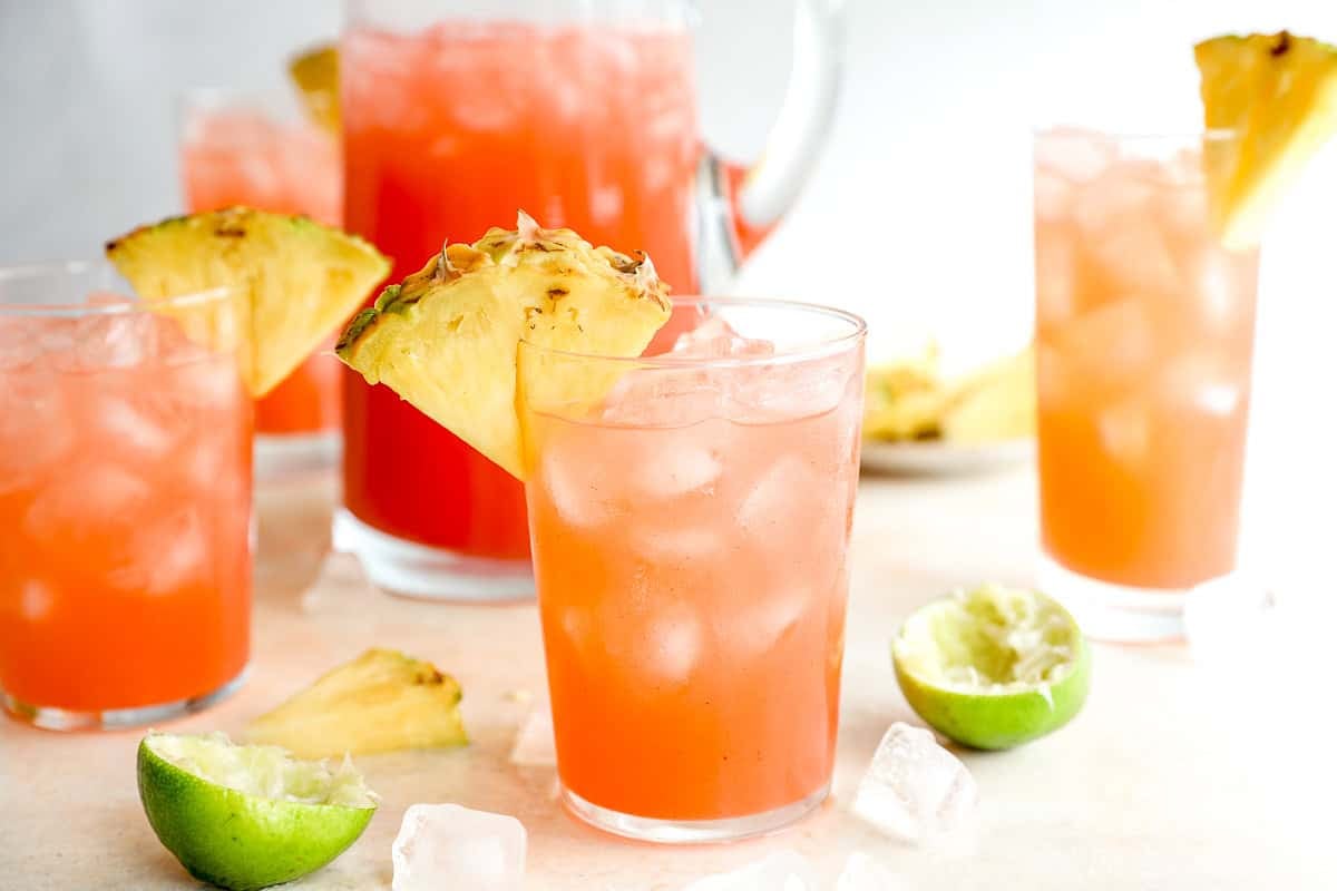 glasses of fruit punch garnished with a pineapple slice.