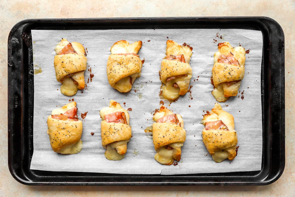 ham and cheese croissants on a baking sheet
