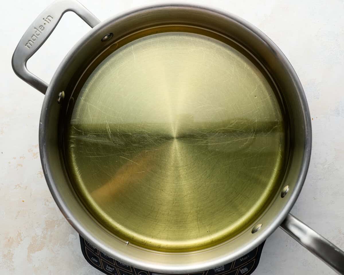 Oil heating in a large pot on the stovetop, ready for frying beer battered fish.