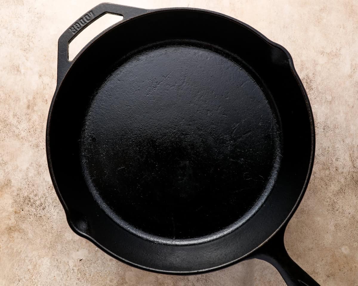 Empty cast iron skillet preheating on the stovetop before searing steaks
