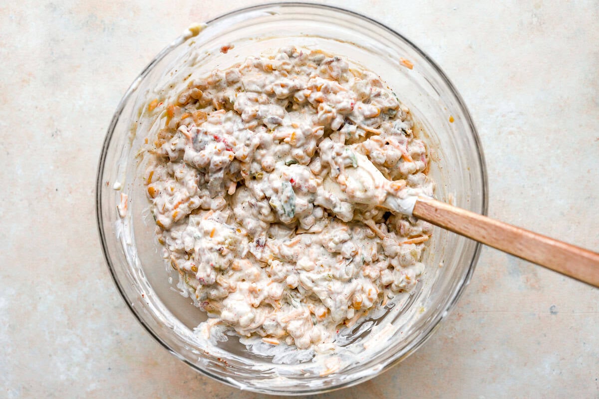 Crack corn dip fully mixed in a glass bowl, showing a thick and creamy texture.