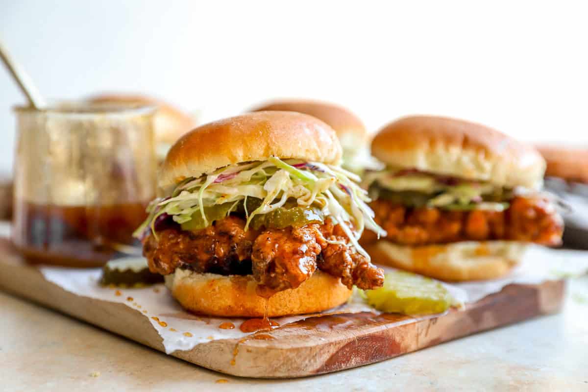 Crispy hot honey chicken sliders with coleslaw and pickles ready for serving.