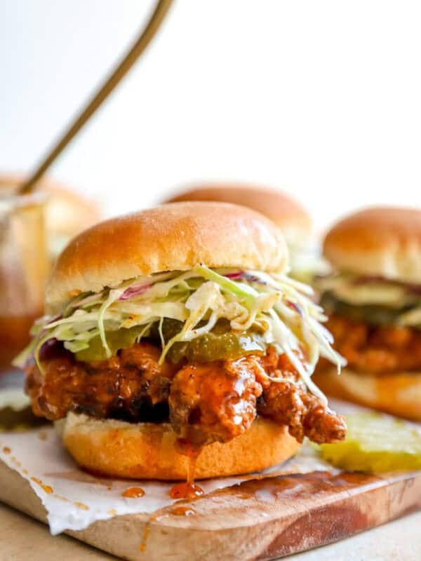 Crispy hot honey chicken slider on a toasted brioche bun topped with creamy coleslaw and pickle chips.