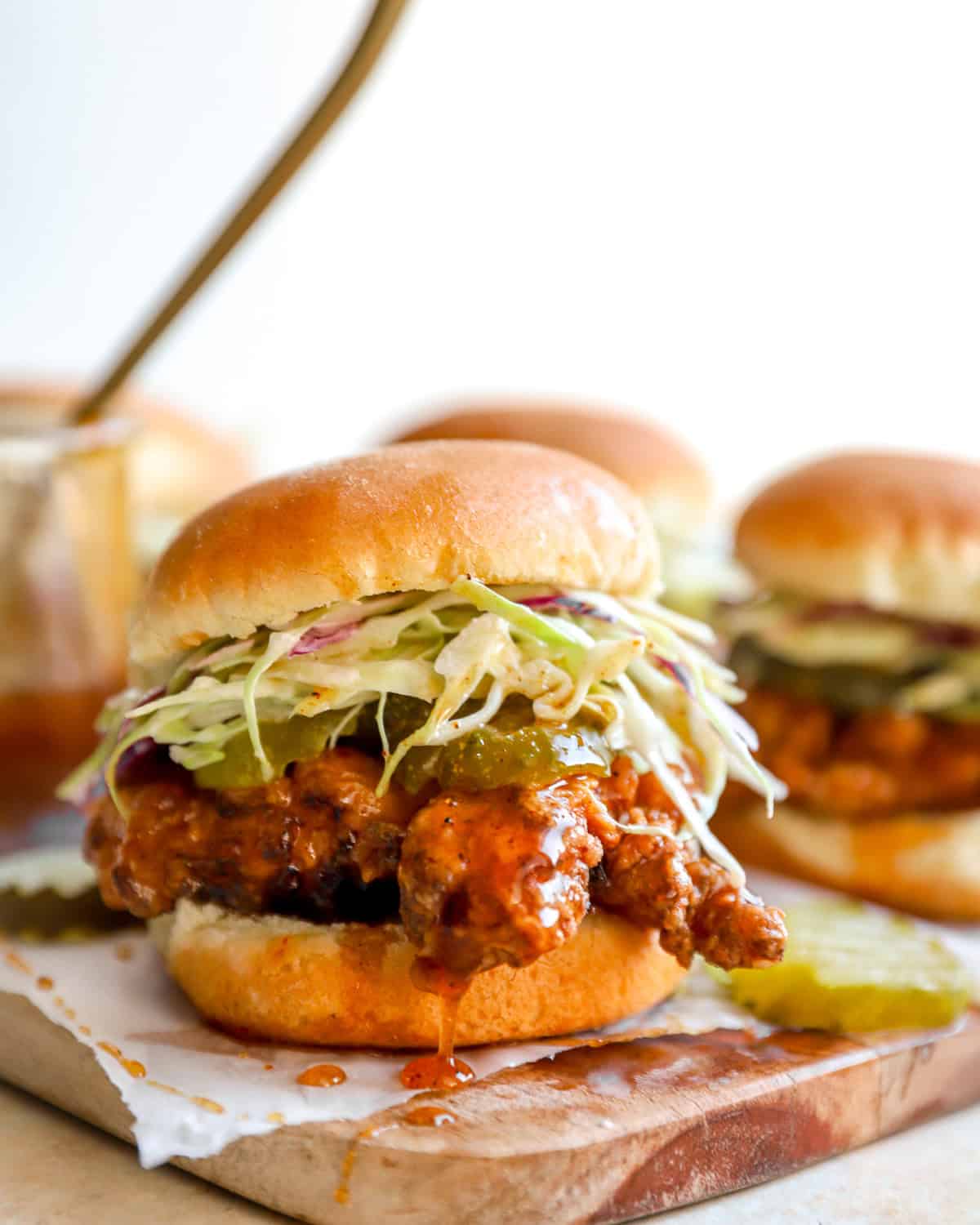 Crispy hot honey chicken slider on a toasted brioche bun topped with creamy coleslaw and pickle chips.