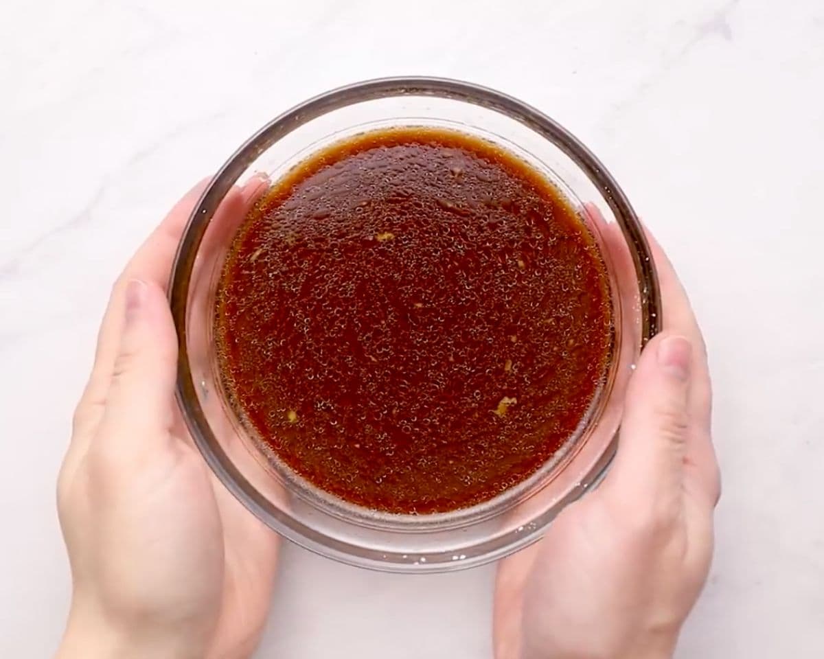 Homemade chicken stir fry sauce in a glass bowl, showing the glossy soy sauce mixture before cooking