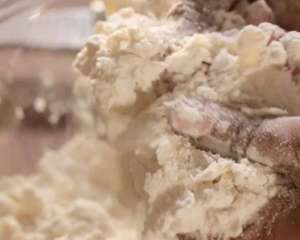 Cold butter being mixed into gluten-free flour mixture for shortbread crust
