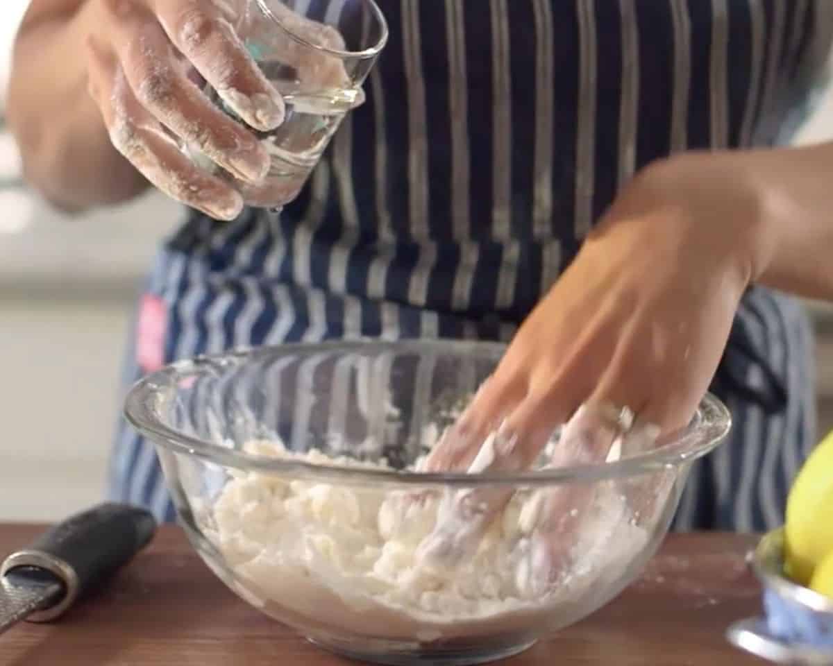 Adding water to gluten-free crust mixture in glass bowl