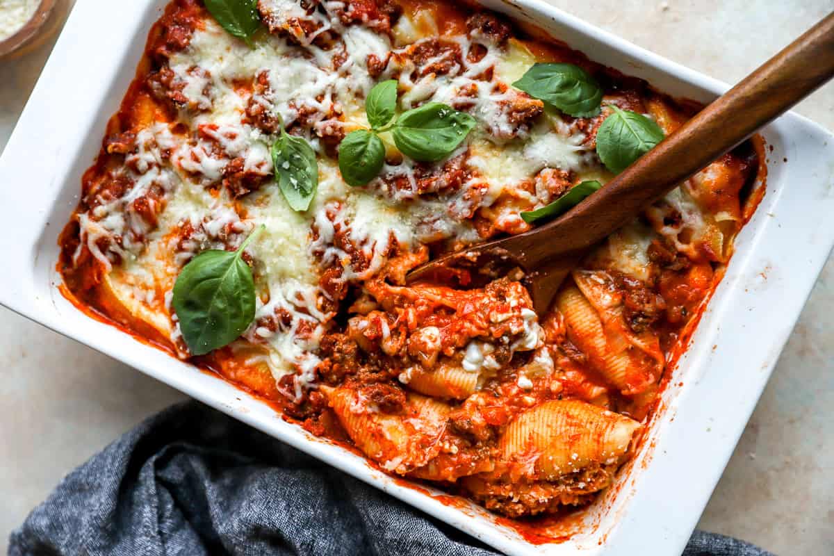 spoon scooping out Italian stuffed shells to serve