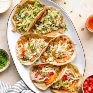 Chicken smash tacos three ways on a serving platter with Caesar, buffalo chicken, and cheeseburger toppings.