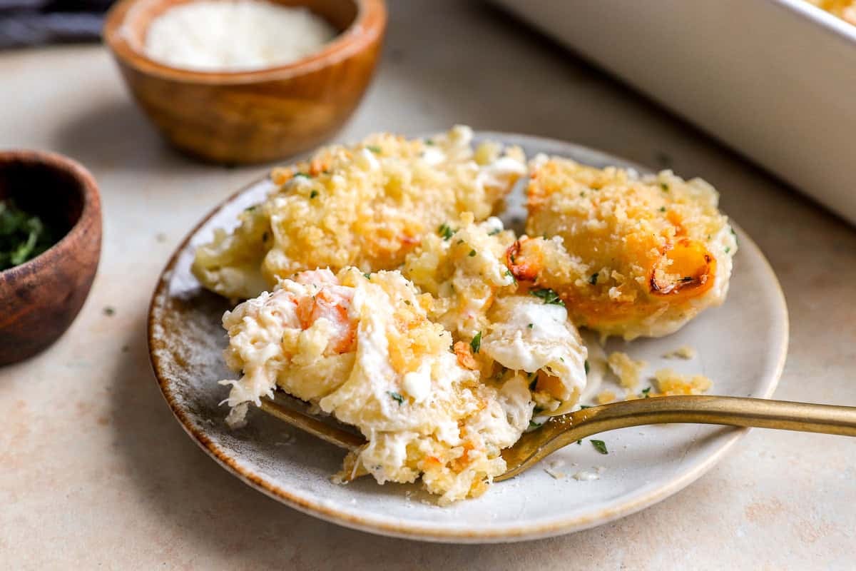 Serving of creamy shrimp and crab seafood stuffed shells on a plate with a fork.