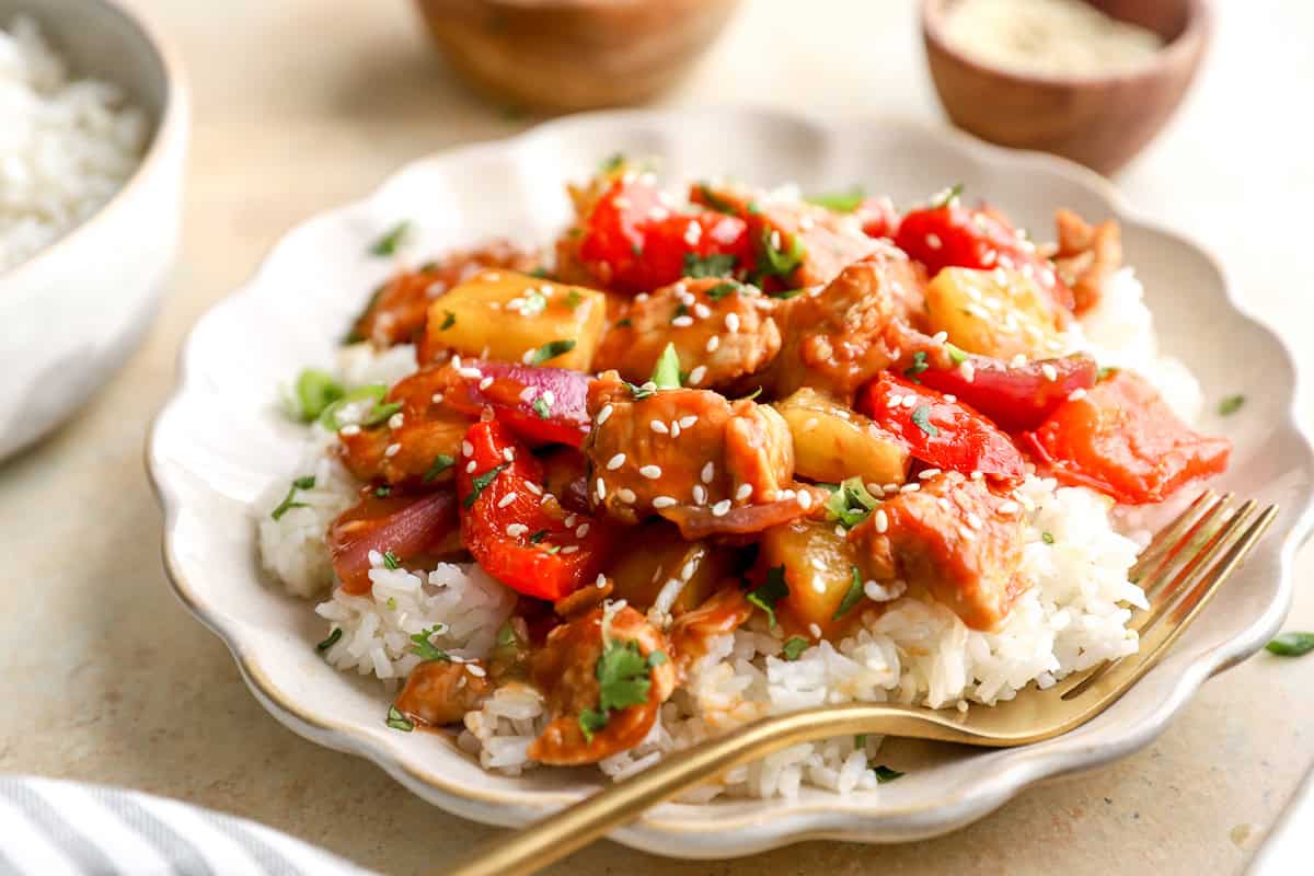 Close-up of Hawaiian chicken with pineapple and peppers over rice on a plate
