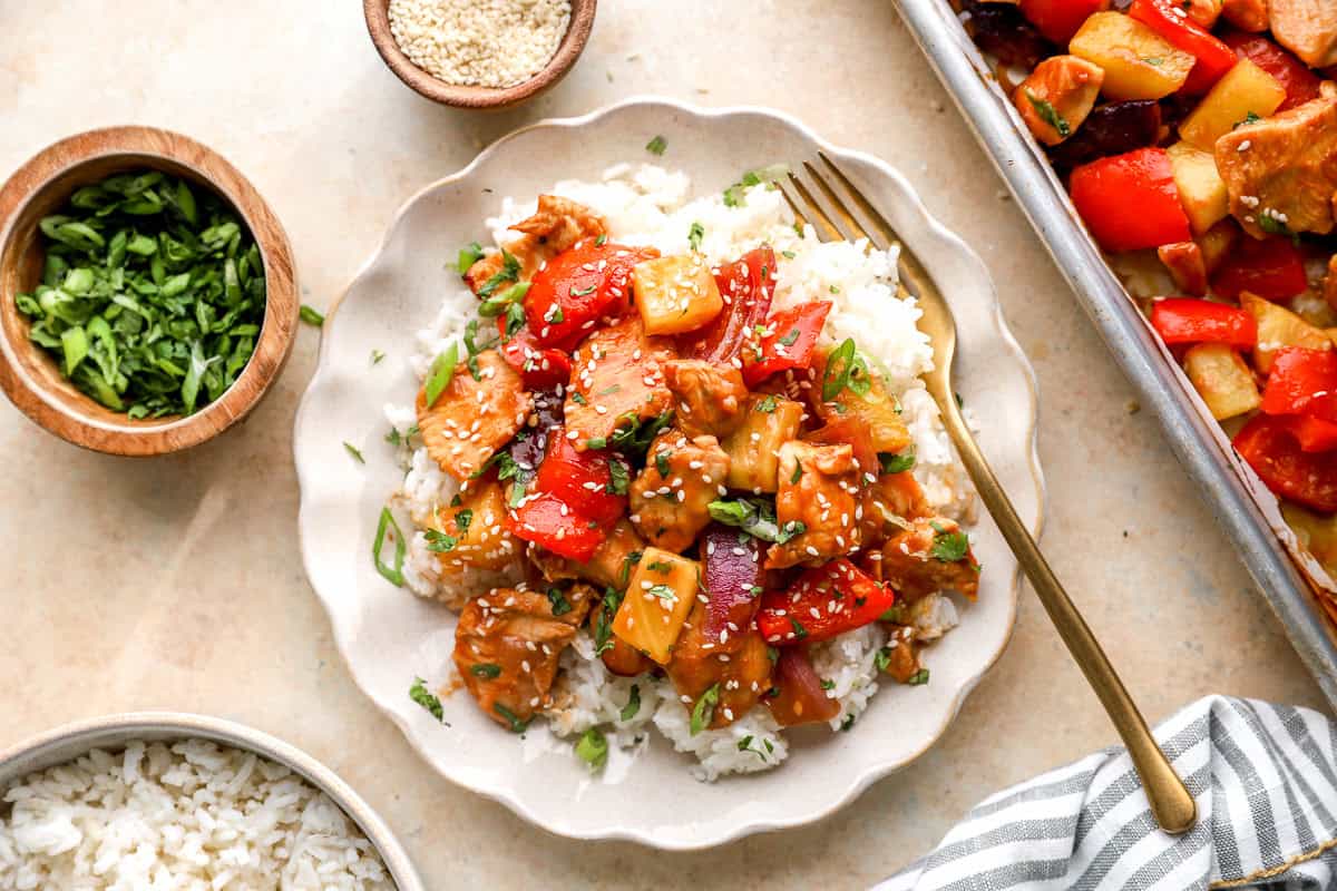 Sheet pan Hawaiian chicken served over white rice with sesame seeds and green onions