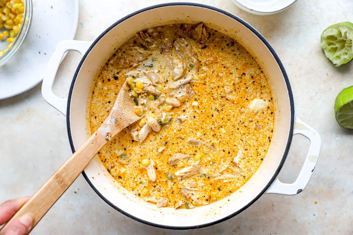 Creamy street corn white chicken chili with shredded chicken, corn, and beans simmering in a Dutch oven