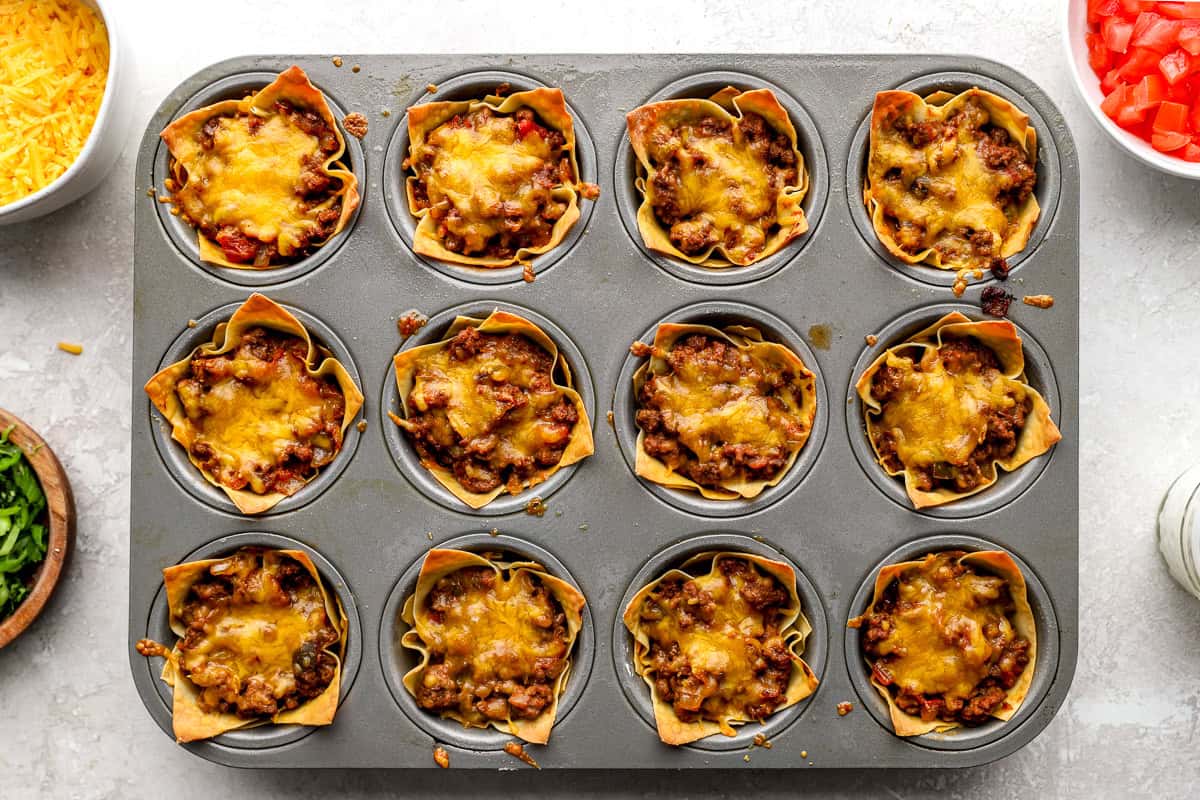 Baked taco cups with melted cheese in crispy wonton wrappers in a muffin pan