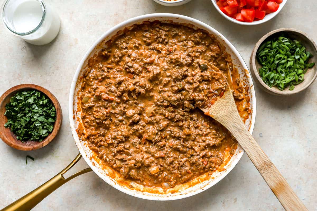 Ground beef taco filling mixed with salsa and cream cheese in a skillet.
