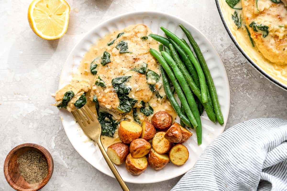 overhead view of plated chicken florentine served with roasted potatoes and green beans