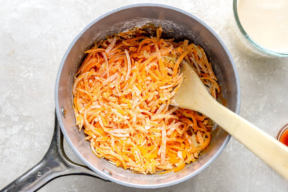 Shredded cheddar and pepper jack cheese tossed with cornstarch in a saucepan.
