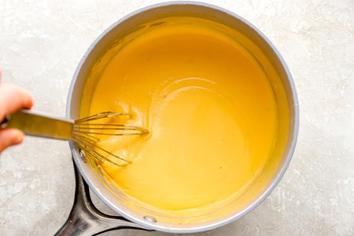 whisk stirring pot of nacho cheese sauce