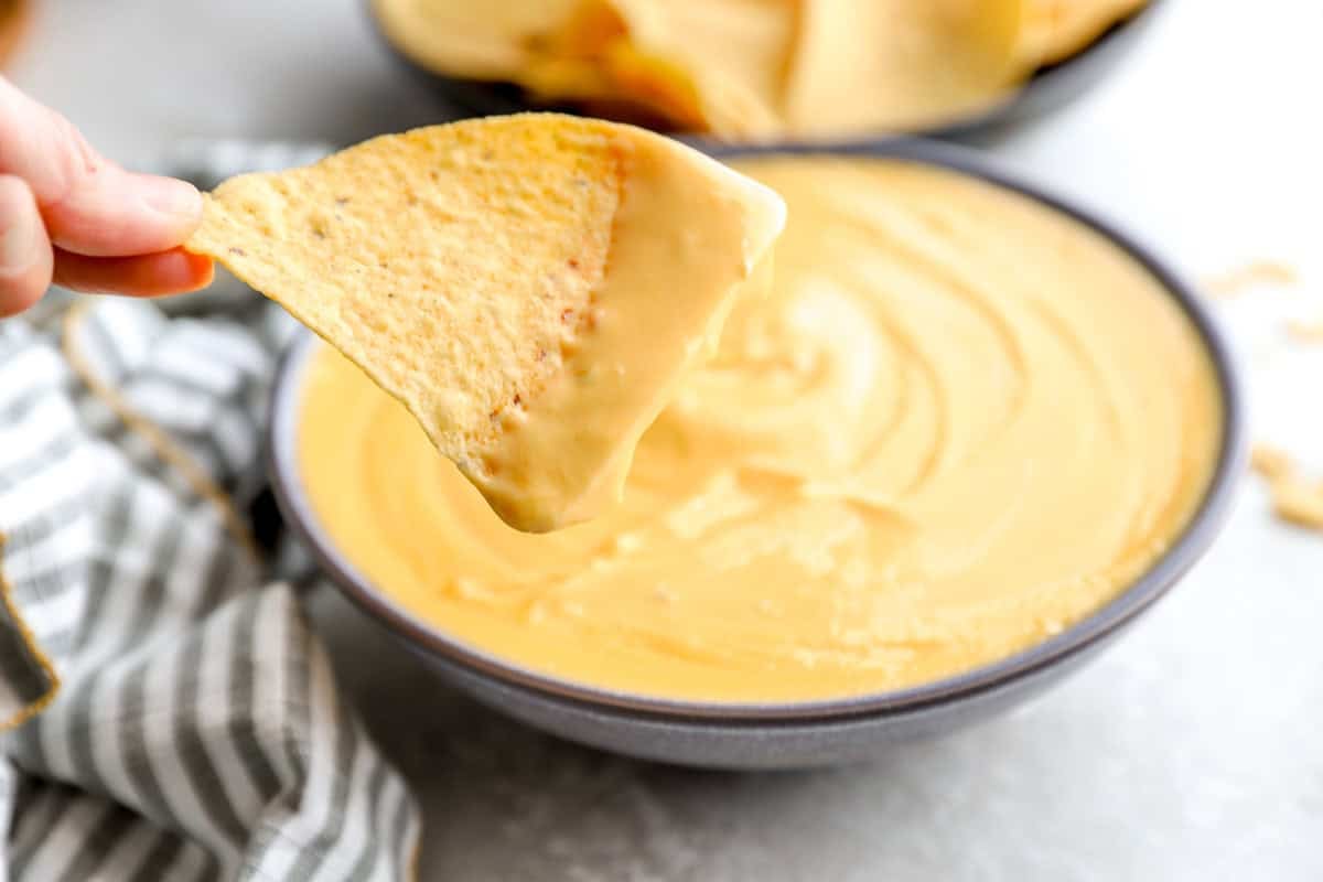 chip dipped into nacho cheese sauce