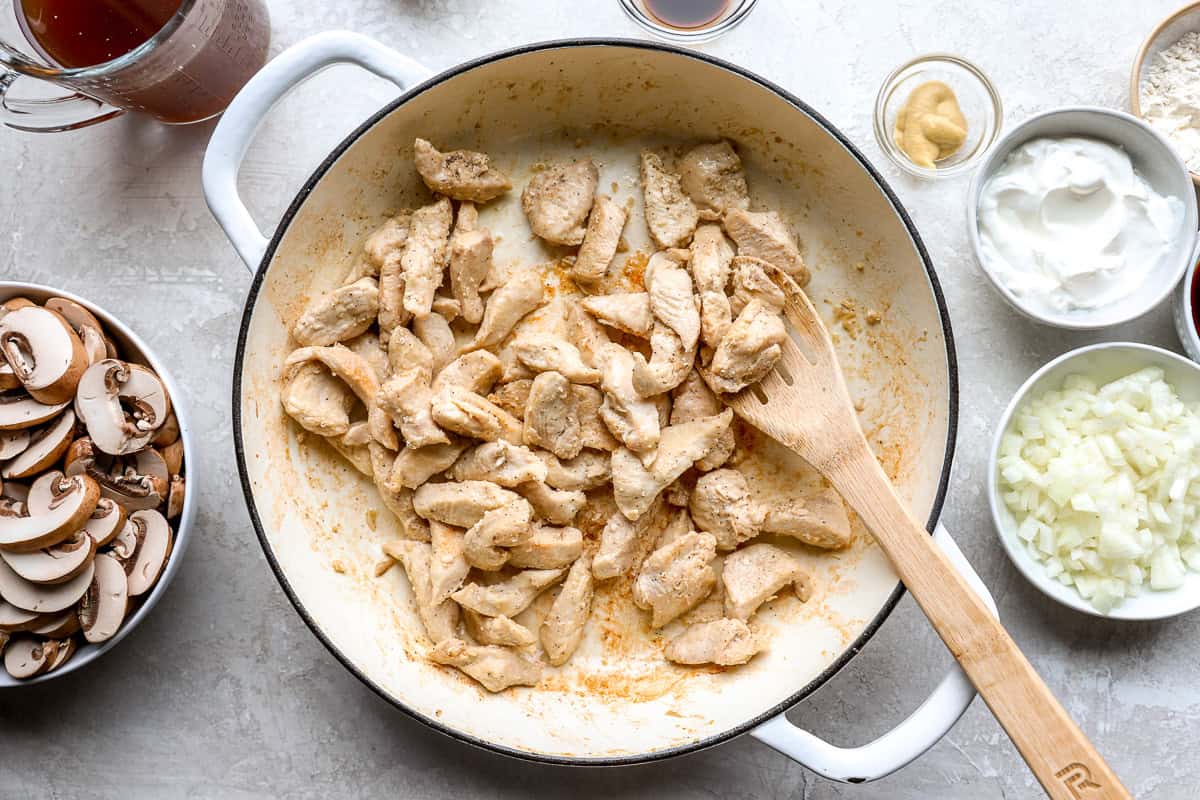 Sliced chicken browning in a skillet for homemade chicken stroganoff
