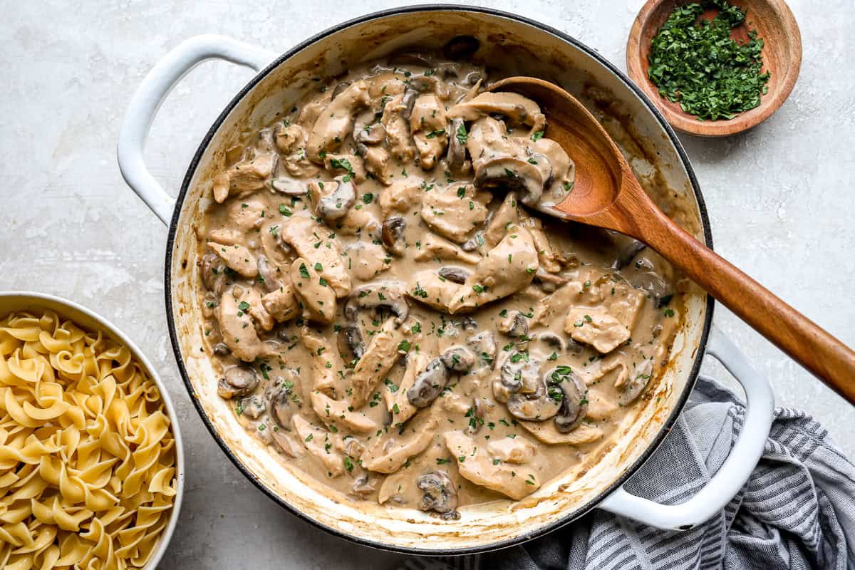 Creamy chicken stroganoff sauce with mushrooms and sour cream in a skillet