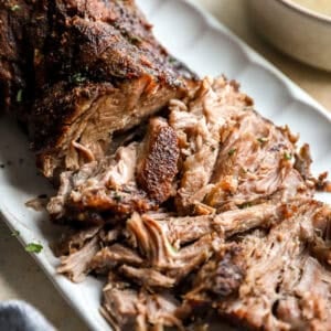 Shredded roasted pork shoulder with crispy browned edges served on a platter.