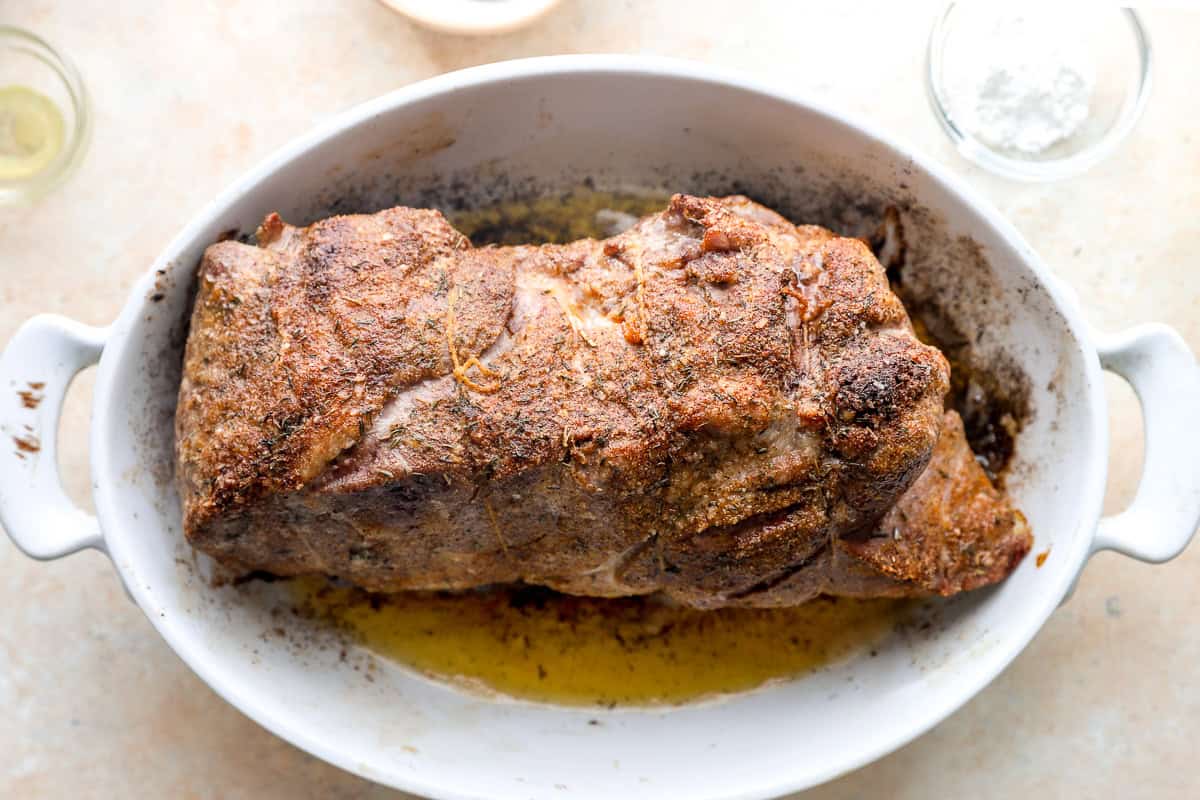 Pork shoulder roast after the initial high-heat roast with a lightly browned crust.
