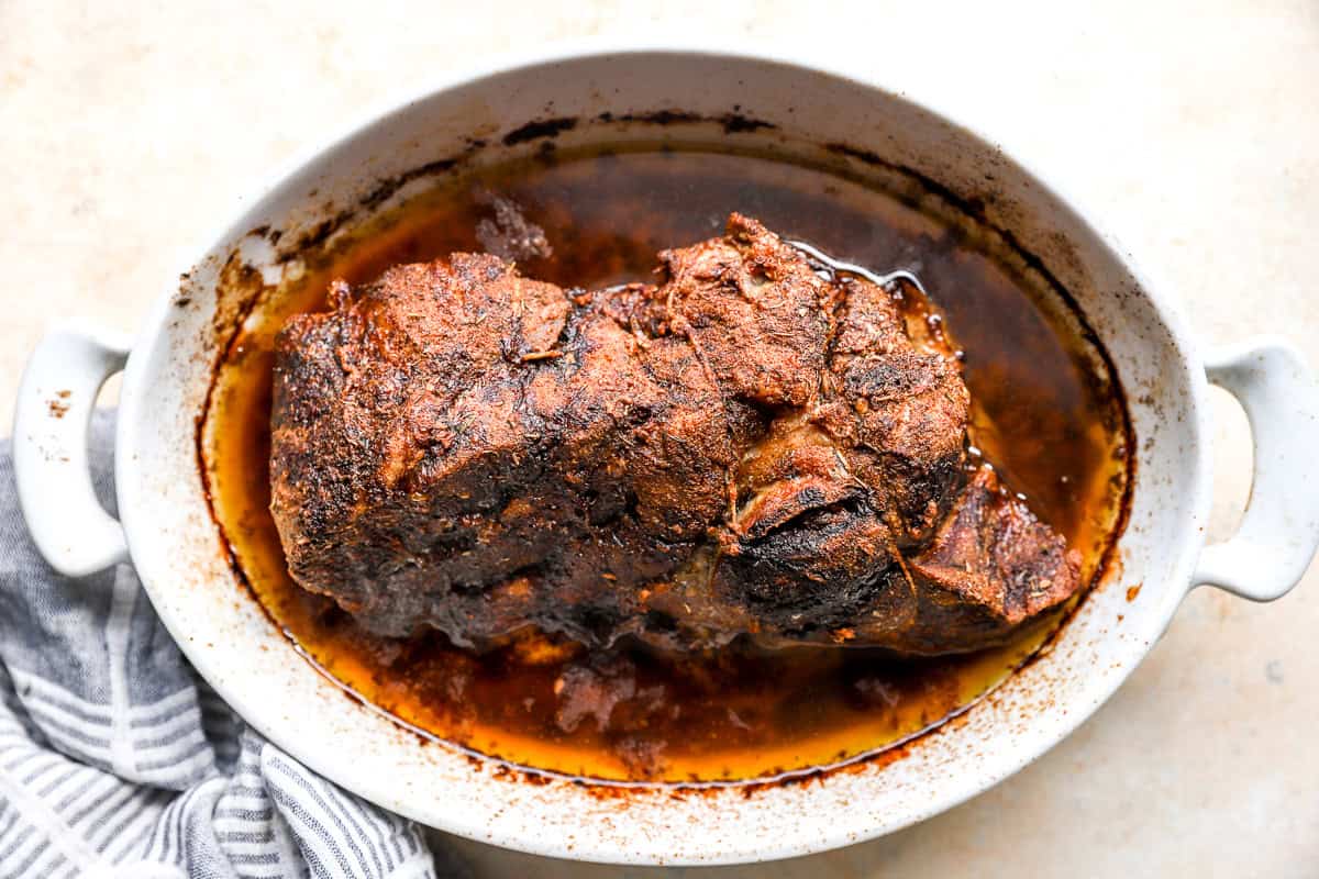 Slow roasted pork shoulder in pan juices after cooking low and slow in the oven.