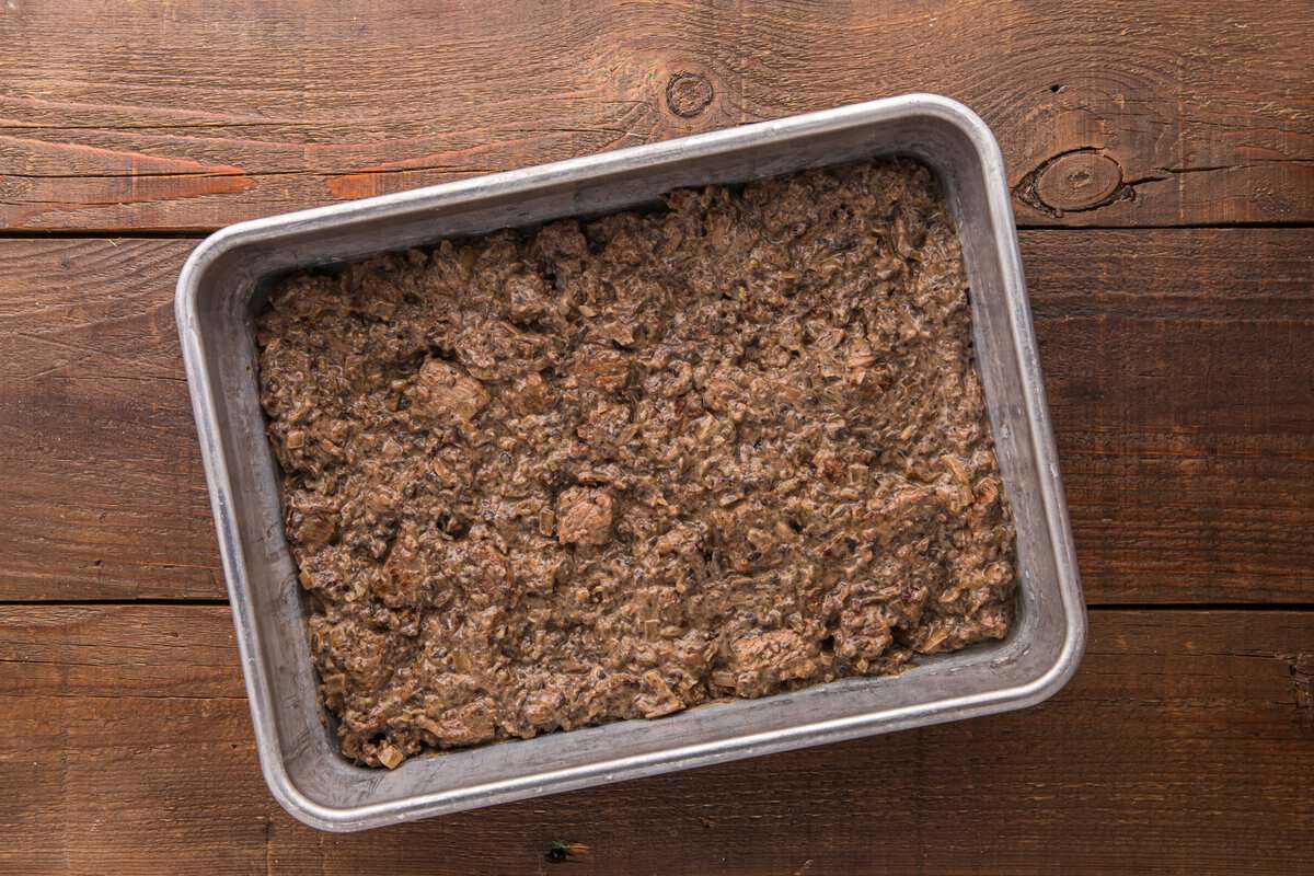 Creamy beef and mushroom filling spread evenly into a 9x13 metal baking dish