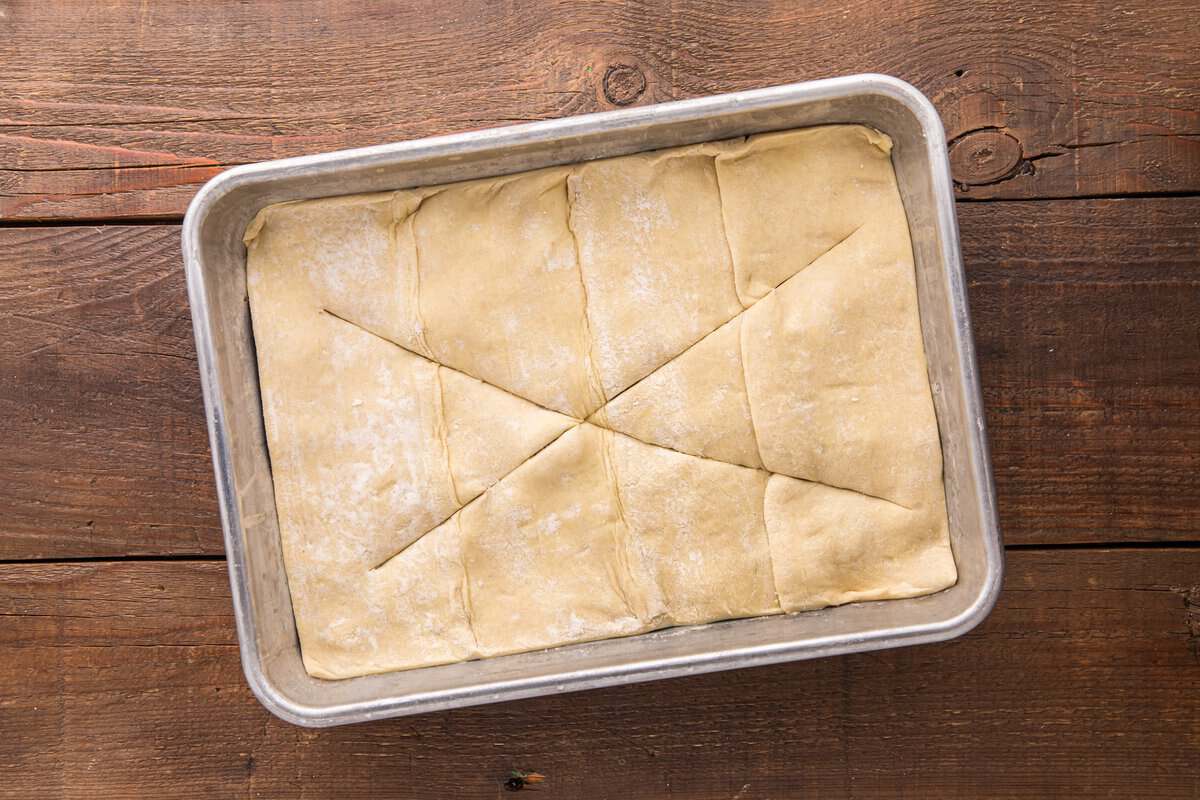 Puff pastry sheet laid over the beef Wellington pot pie bake filling with slits cut for ventilation