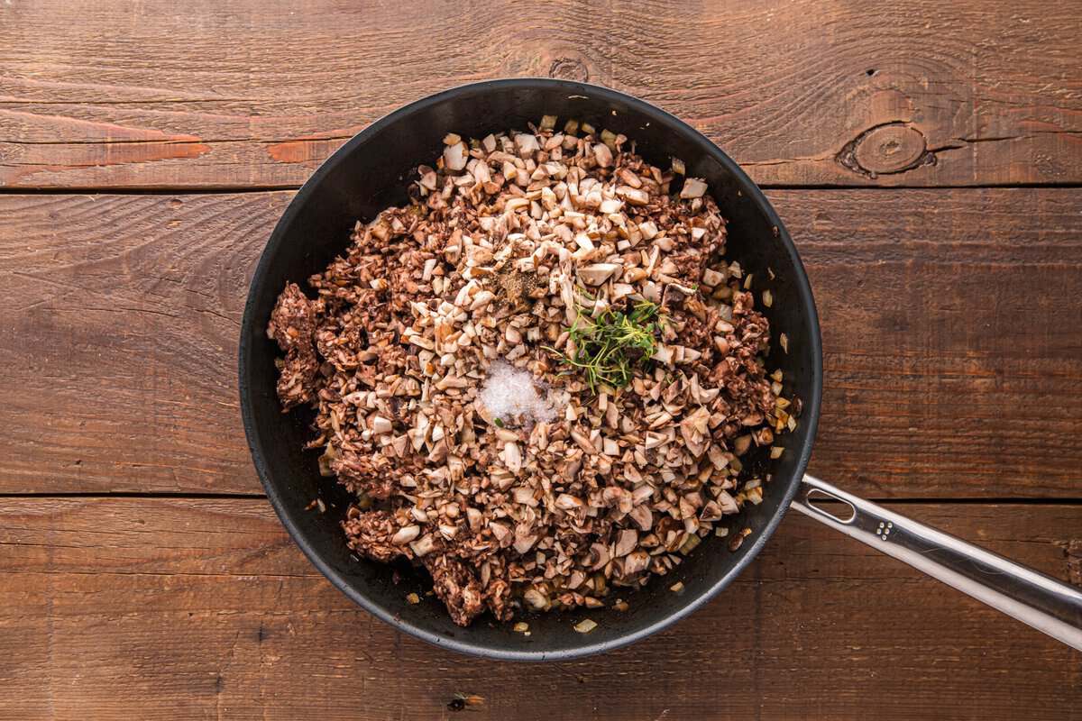Finely chopped mushrooms added to the skillet with onion, garlic, salt, pepper, and fresh thyme