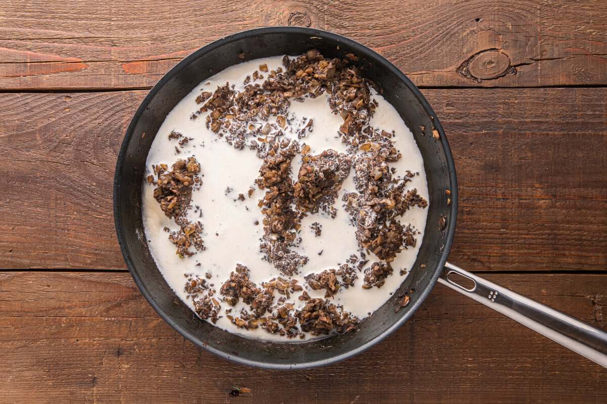 Heavy cream and beef broth poured into the mushroom mixture in a skillet to make the creamy Dijon sauce