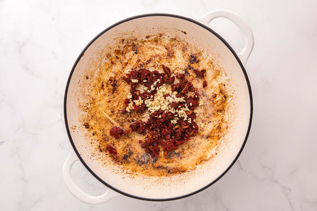 Minced garlic and chopped sun-dried tomatoes added to the skillet with the chicken fon