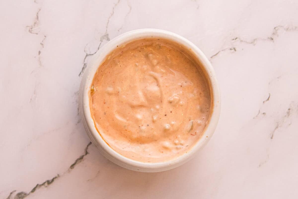 A small bowl of creamy, tangy Reuben sauce made with mayo, ketchup, relish, and Dijon mustard.