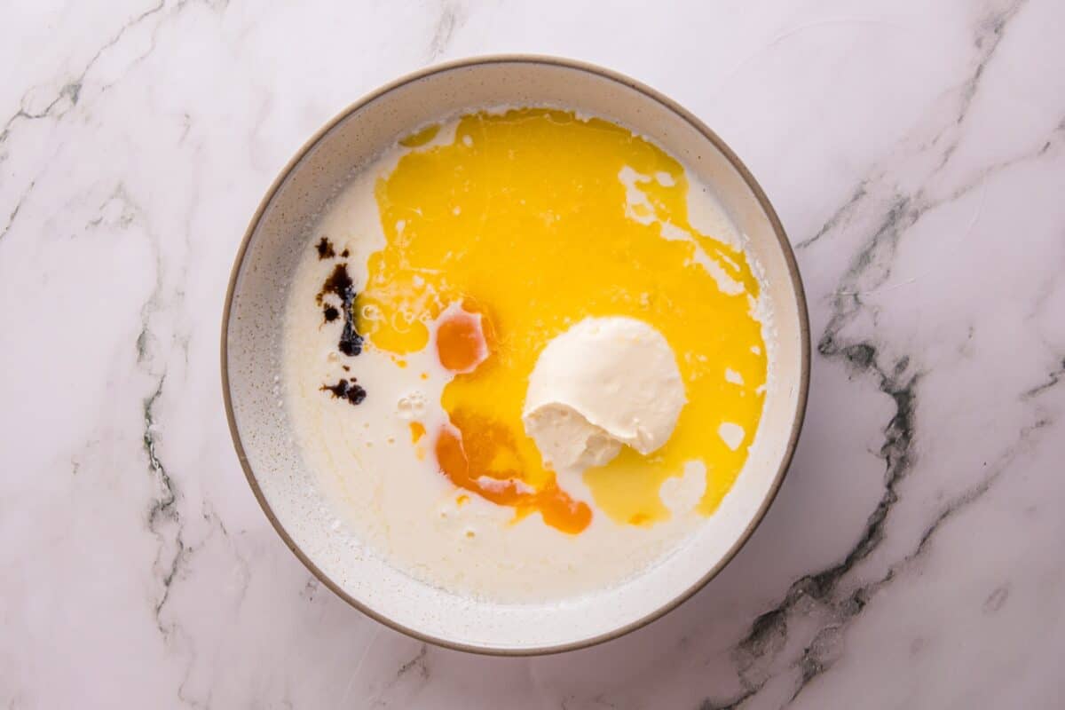 Buttermilk, melted butter, egg, sour cream, and vanilla extract in a bowl before whisking together