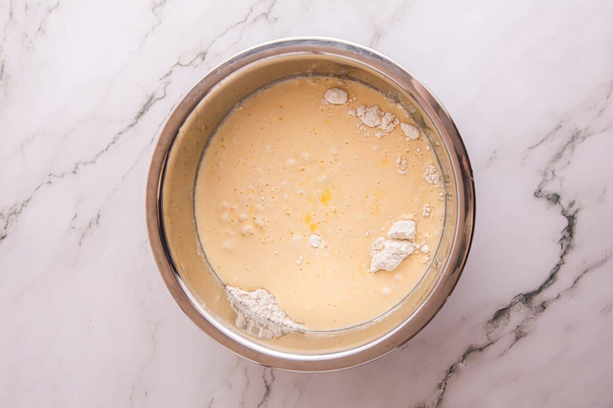 Pancake batter with streaks of flour being stirred into the wet ingredients